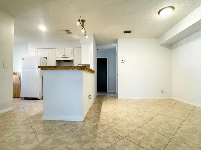a view of a kitchen with a sink and a refrigerator