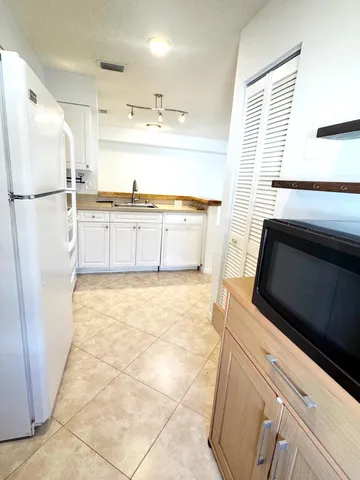 a kitchen with stainless steel appliances a refrigerator sink and cabinets