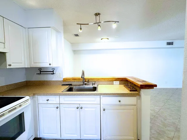 a view of a kitchen with a sink and cabinets