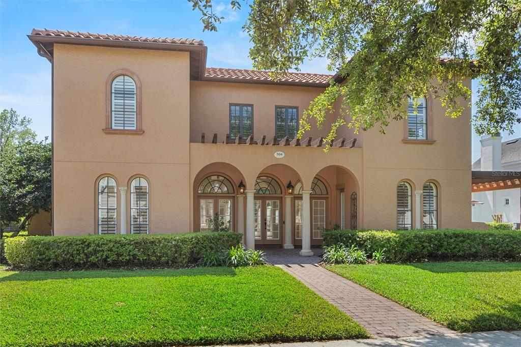 a front view of a house with garden and trees
