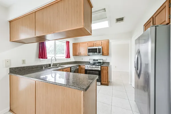 a kitchen with stainless steel appliances granite countertop a sink stove and refrigerator