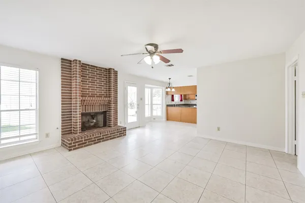 an empty room with fireplace and windows