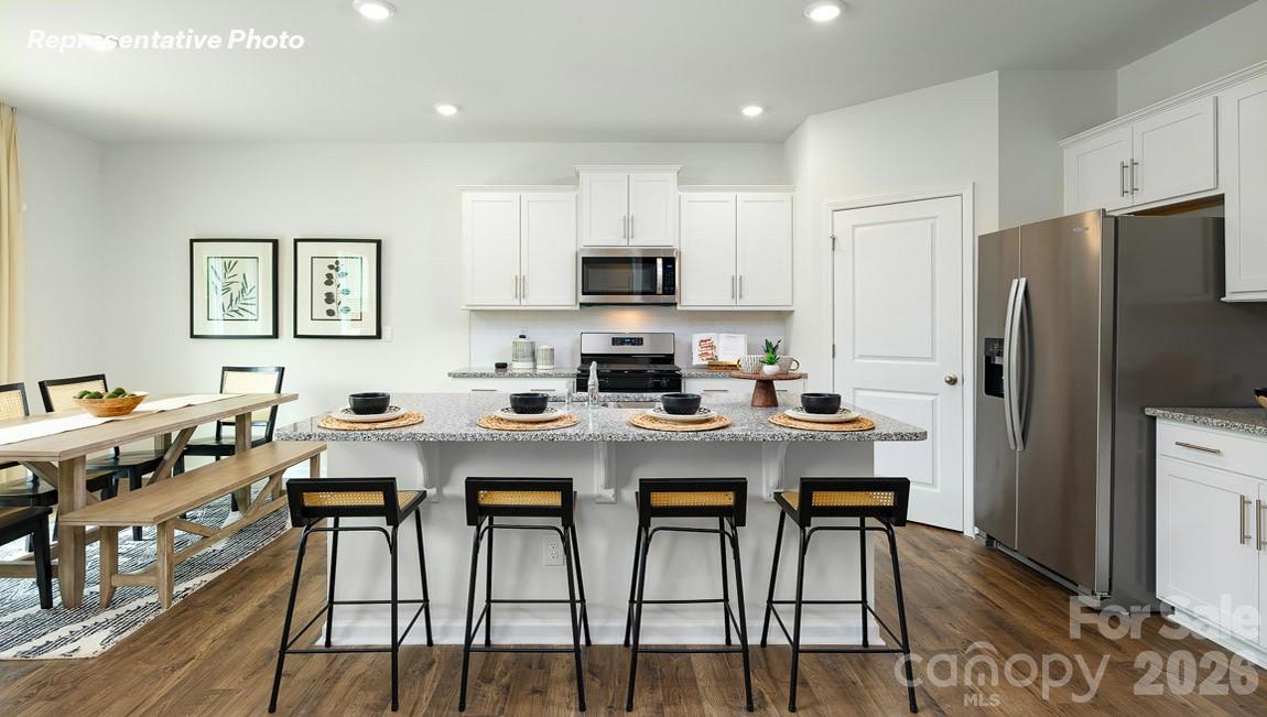 7612 Bainbridge Road Sherrills Ford, NC 28673 - Photo 6 of 37 a kitchen with stainless steel appliances a stove a refrigerator a sink a dining table and chairs