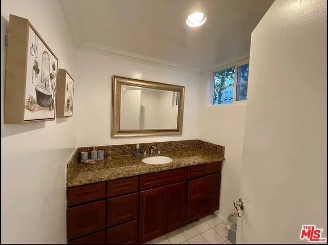 a bathroom with a granite countertop sink and a mirror