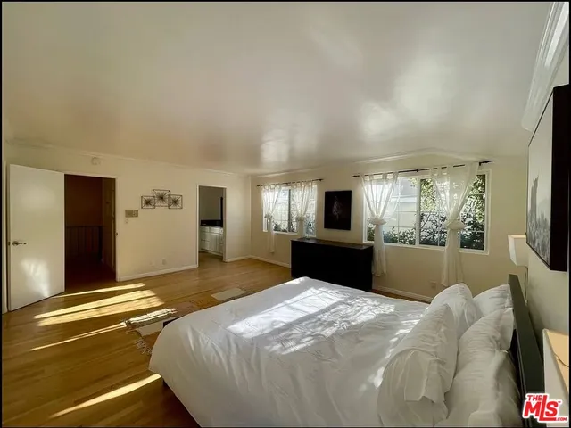 a bedroom with a bed and large windows