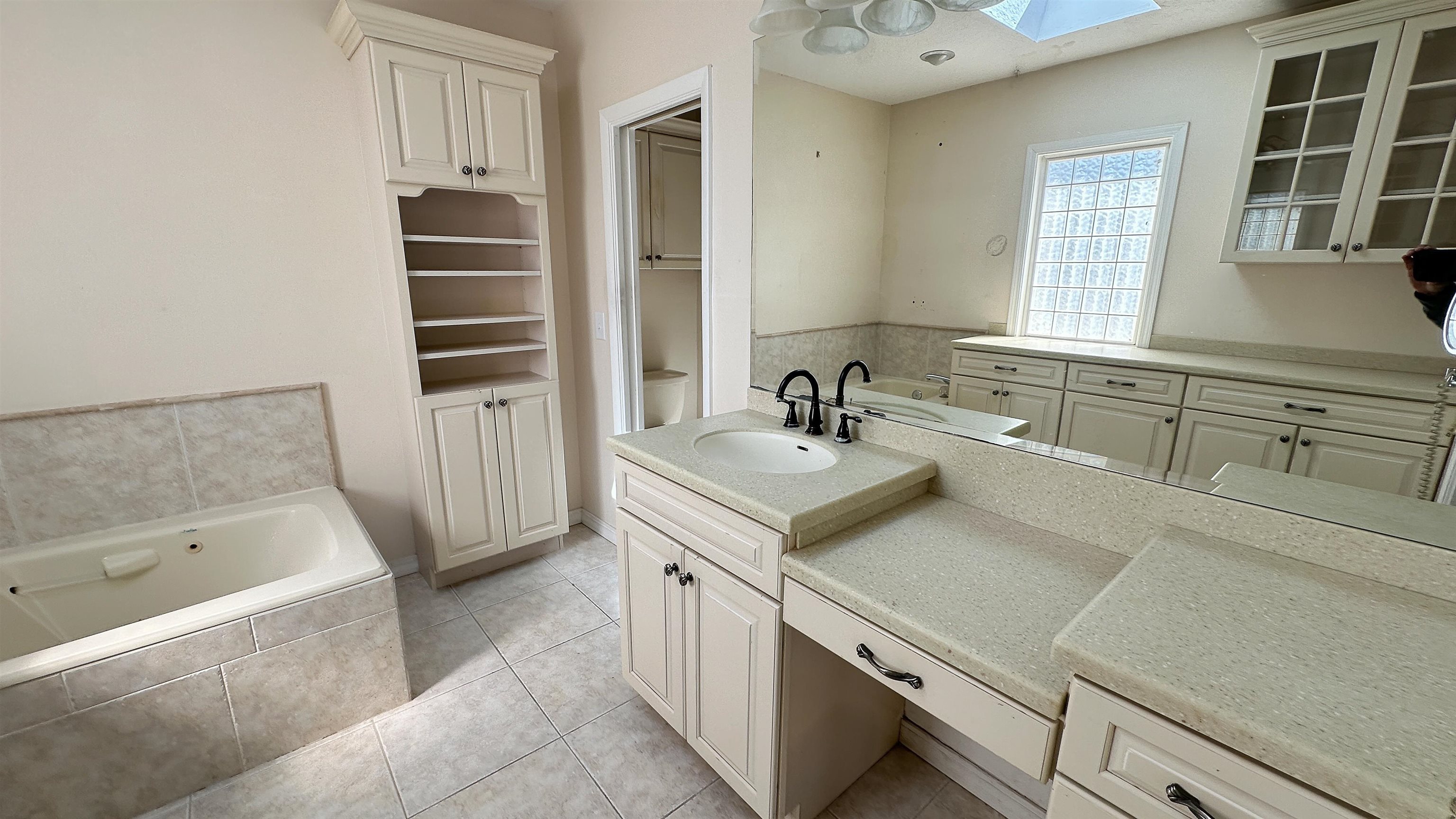 2 11th Street St. Augustine Beach, FL 32080 - Photo 3 of 72 Bathroom with a garden tub, vanity, a skylight, light tile patterned floors, and a closet