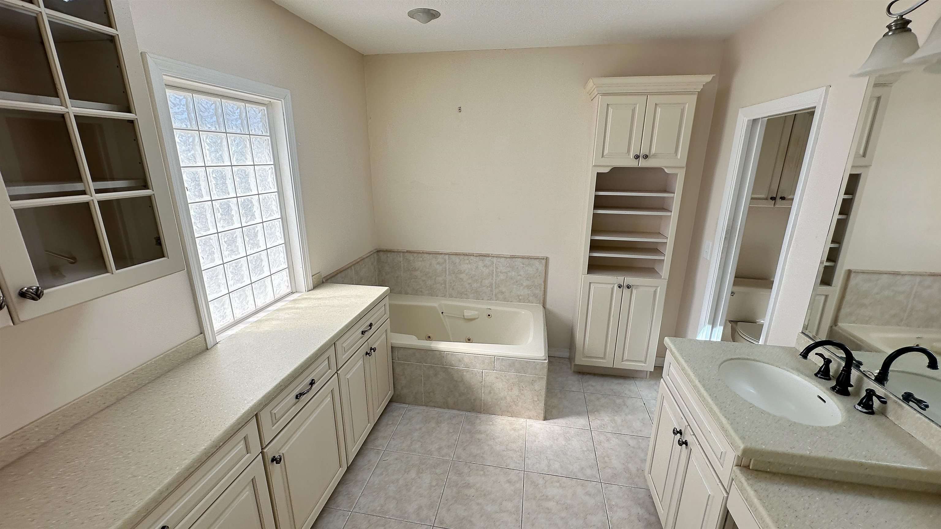2 11th Street St. Augustine Beach, FL 32080 - Photo 4 of 72 Full bathroom featuring a tub with jets, two vanities, light tile patterned floors, and a closet