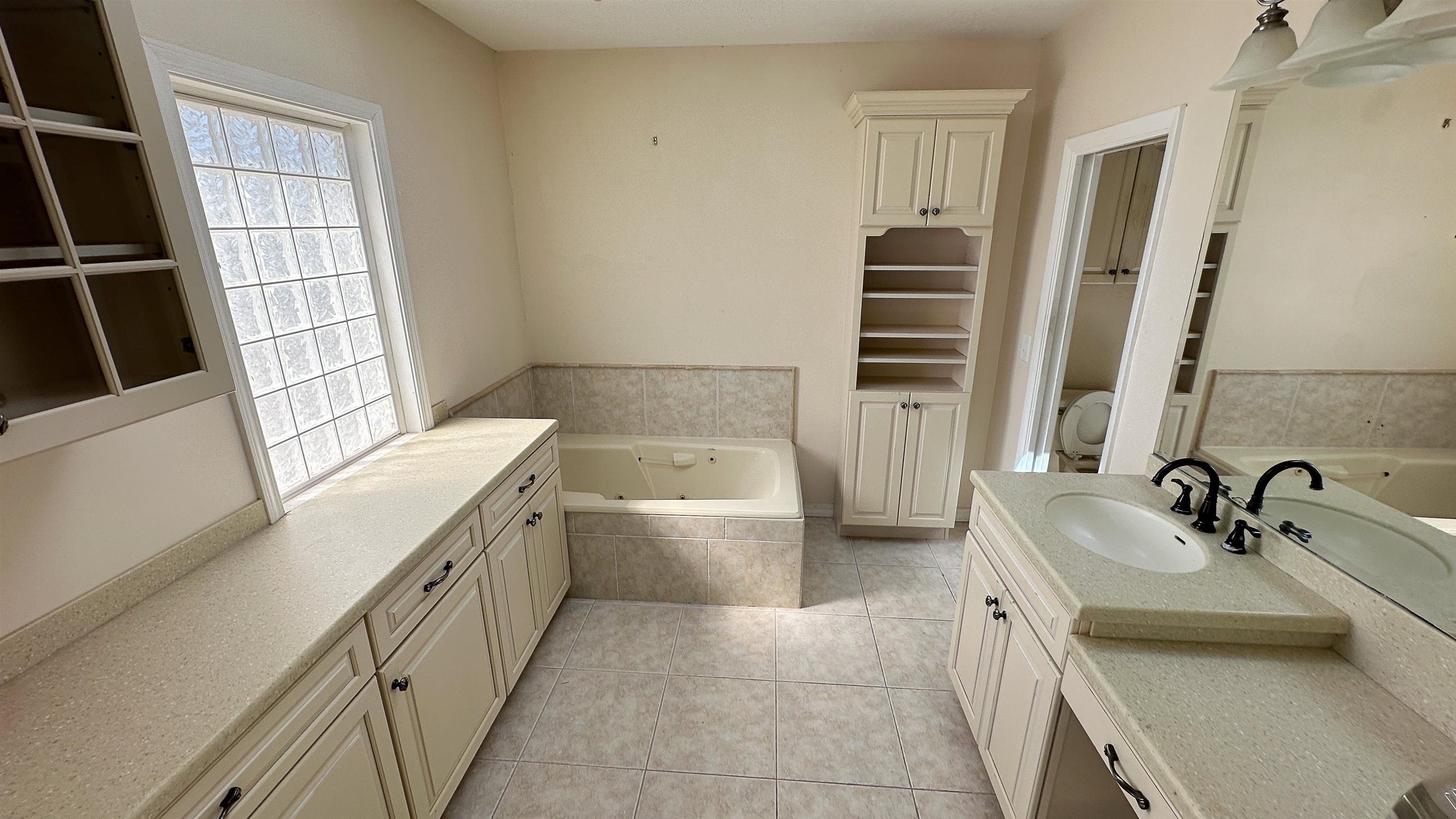 2 11th Street St. Augustine Beach, FL 32080 - Photo 56 of 72 Bathroom featuring a jetted tub, vanity, light tile patterned floors, and a closet