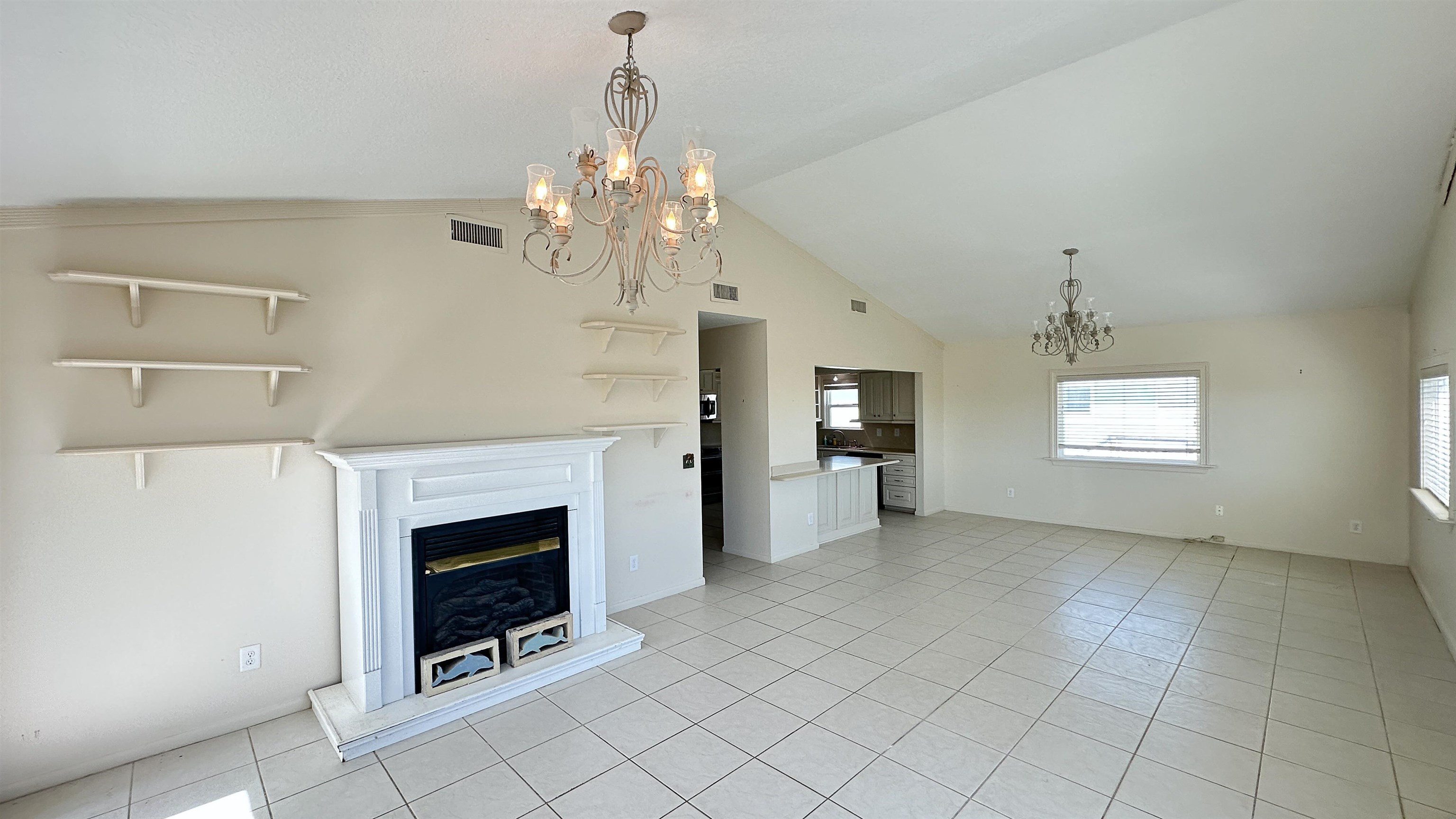 2 11th Street St. Augustine Beach, FL 32080 - Photo 59 of 72 Unfurnished living room with suspended lighting, a glass covered fireplace, light tile patterned flooring, and lofted ceiling