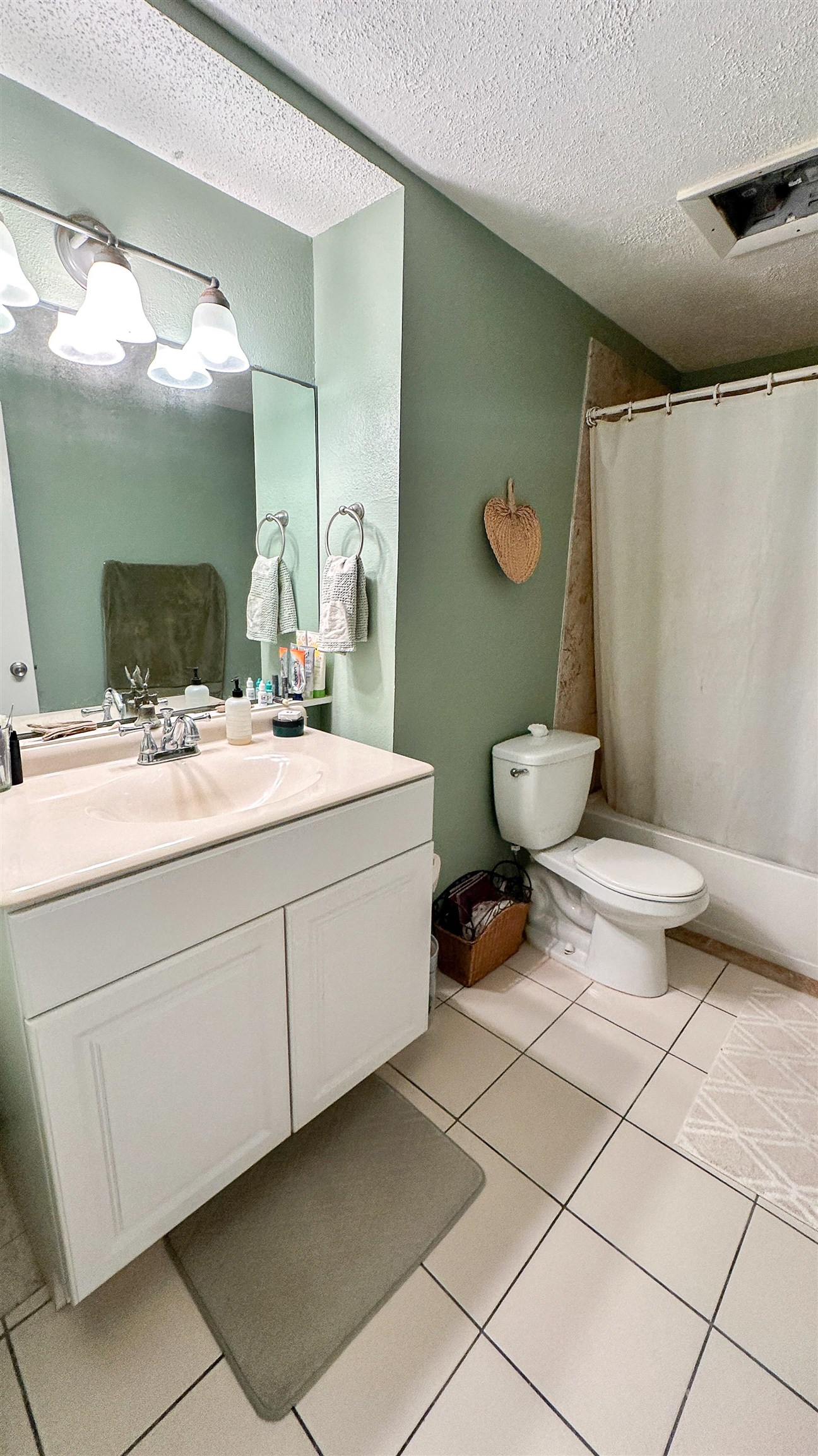 2 11th Street St. Augustine Beach, FL 32080 - Photo 68 of 72 Bathroom featuring vanity, a textured ceiling, and light tile patterned floors