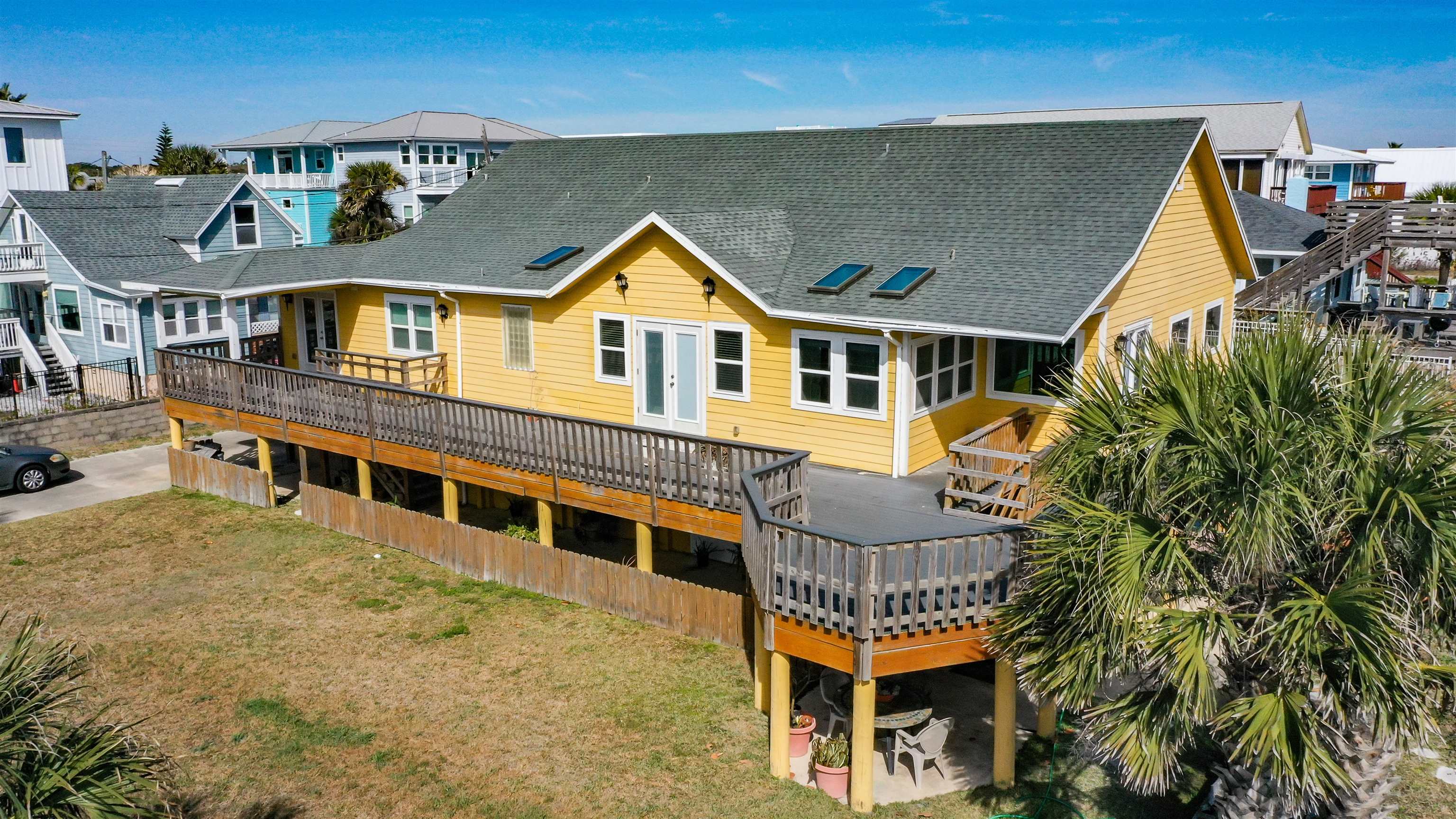 2 11th Street St. Augustine Beach, FL 32080 - Photo 8 of 72 Back of property with a deck, a shingled roof, a residential view, and a lawn