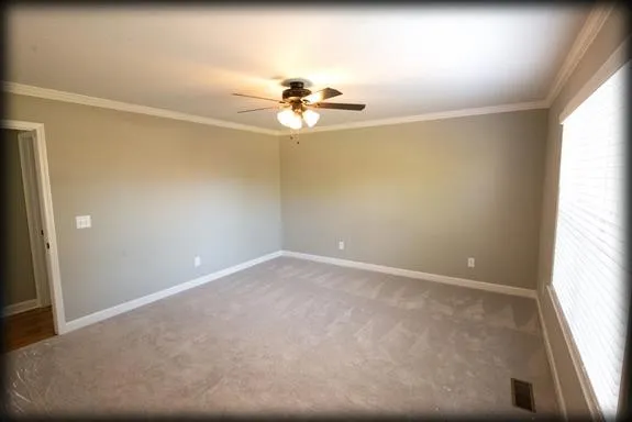 an empty room with a window and a ceiling fan