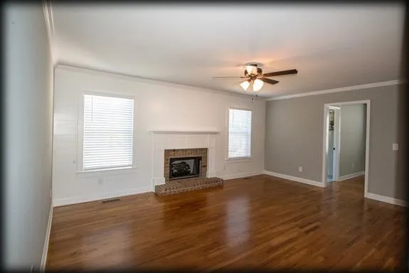 an empty room with fan and windows
