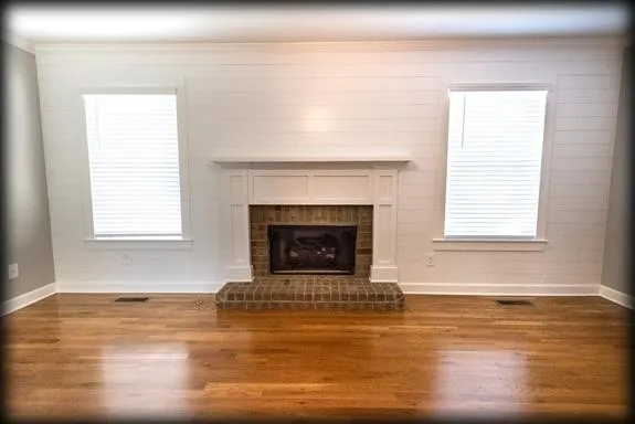 a view of a livingroom with a fireplace and window