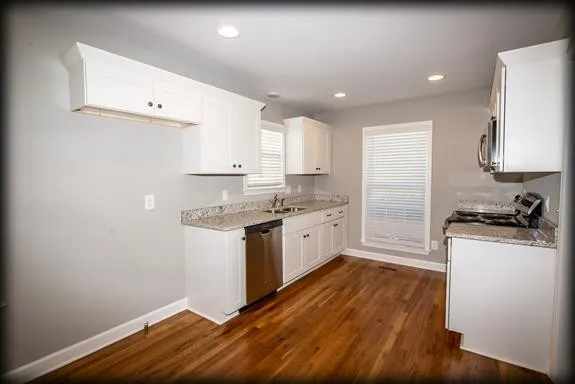 a kitchen with a refrigerator and a stove top oven