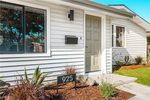 a view of a house with a chair and floor to ceiling windows