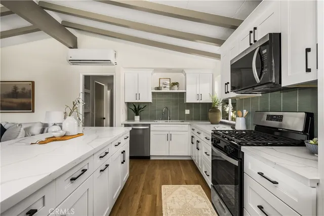 a kitchen with stainless steel appliances granite countertop a stove a sink and a microwave
