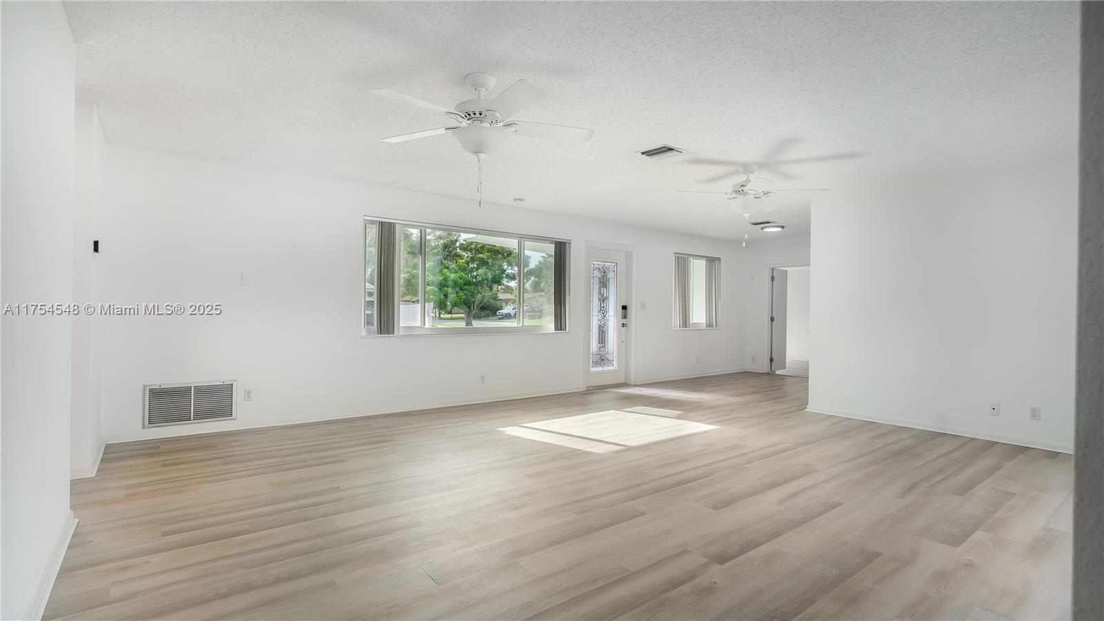 28 Southwest 9th Avenue Boca Raton, FL 33486 - Photo 11 of 27 an empty room with wooden floor and windows