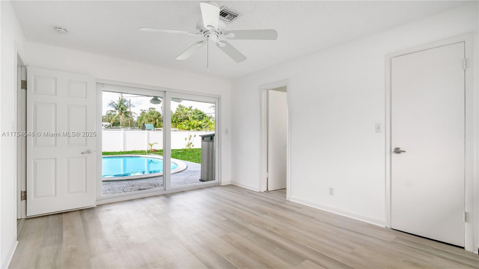 28 Southwest 9th Avenue Boca Raton, FL 33486 - Photo 19 of 27 an empty room with wooden floor fan and windows