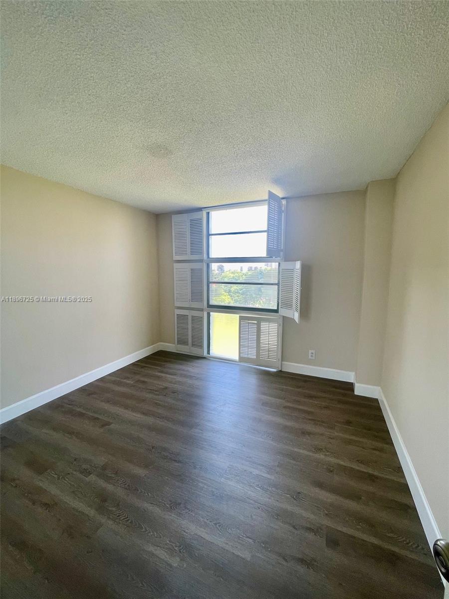 20400 West Country Club Drive, Unit 608 Aventura, FL 33180 - Photo 12 of 19 a view of empty room with wooden floor and fan