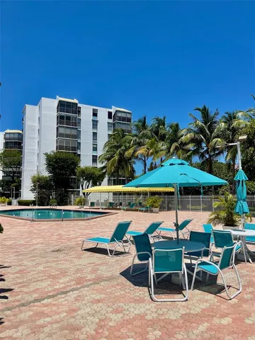 a patio with a table and chairs under an umbrella