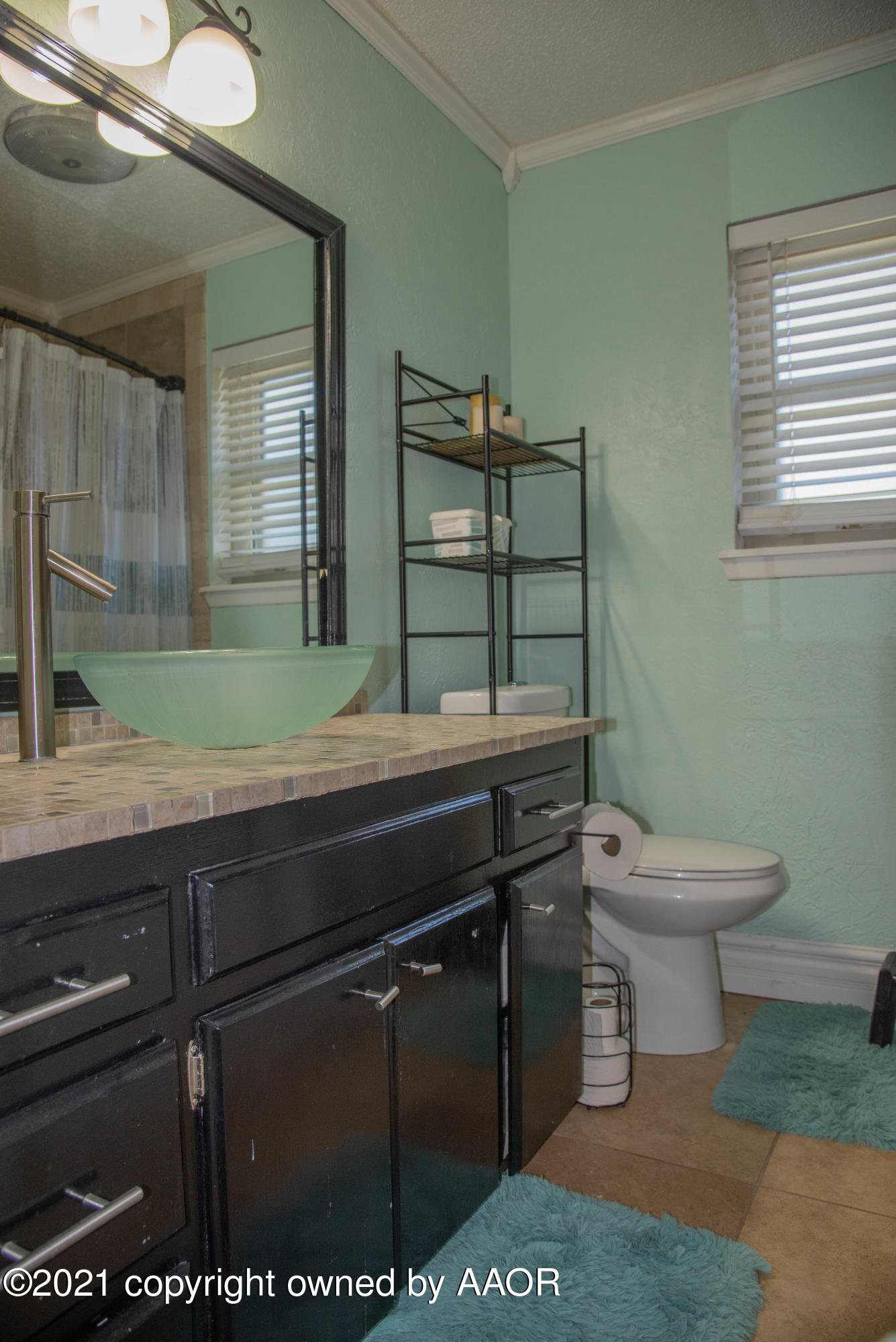 5101 South Austin Street Amarillo, TX 79110 - Photo 13 of 24 a bathroom with a toilet a sink and mirror