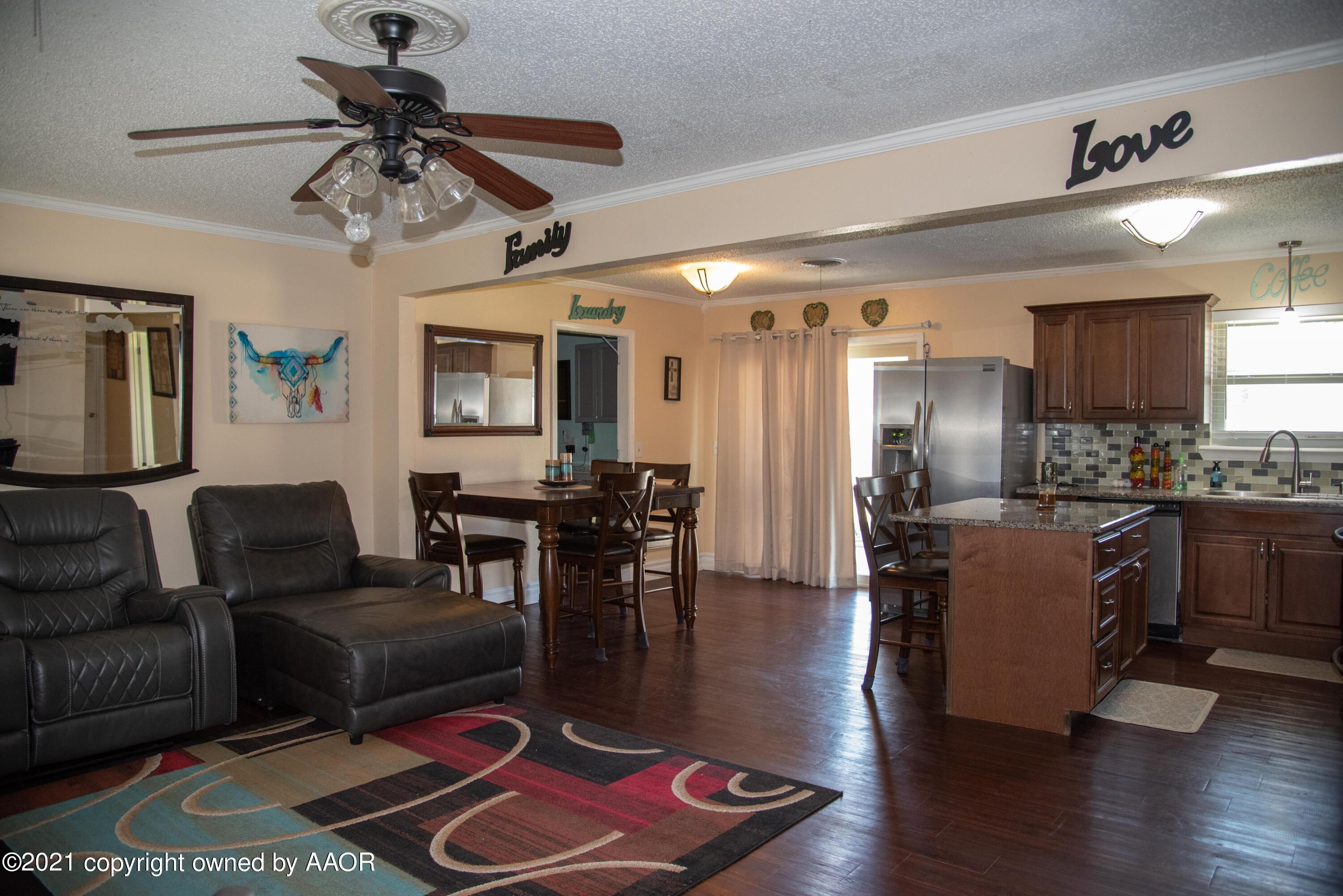 5101 South Austin Street Amarillo, TX 79110 - Photo 3 of 24 a living room with couches and kitchen view with wooden floor