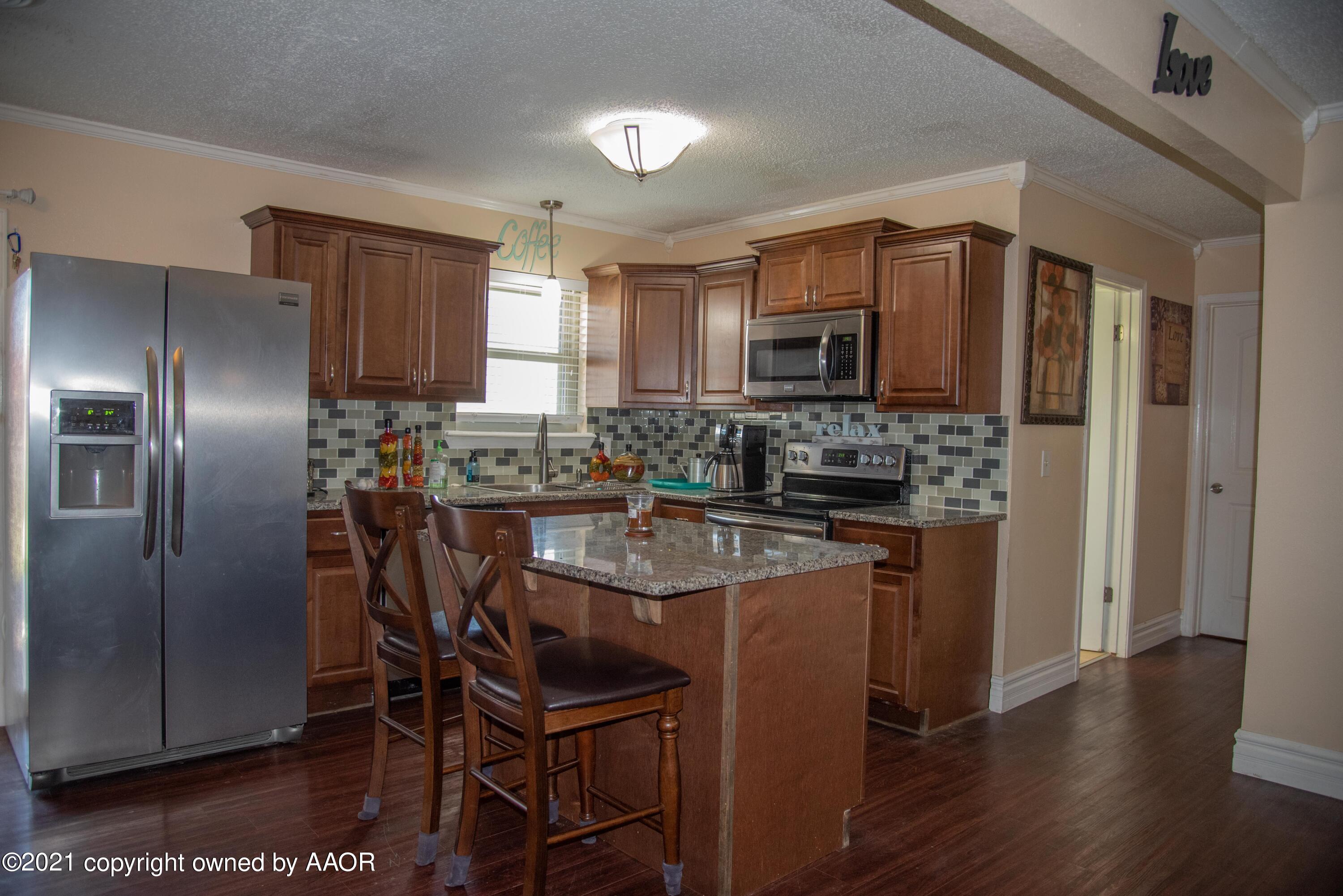 5101 South Austin Street Amarillo, TX 79110 - Photo 6 of 24 a kitchen with stainless steel appliances granite countertop a stove a refrigerator a sink a dining table and chairs