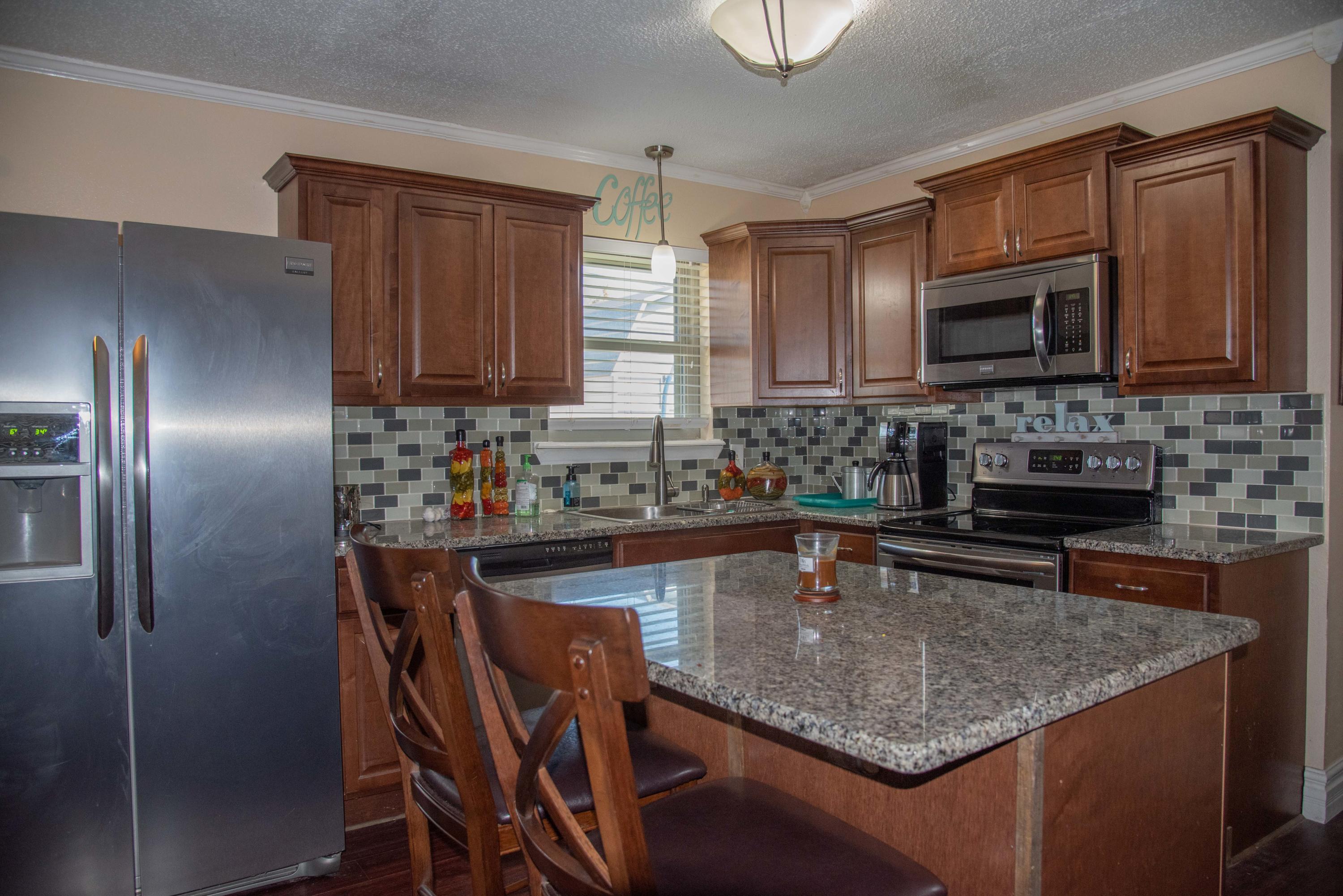 5101 South Austin Street Amarillo, TX 79110 - Photo 7 of 24 a kitchen with stainless steel appliances granite countertop a stove top oven a sink dishwasher a dining table and chairs