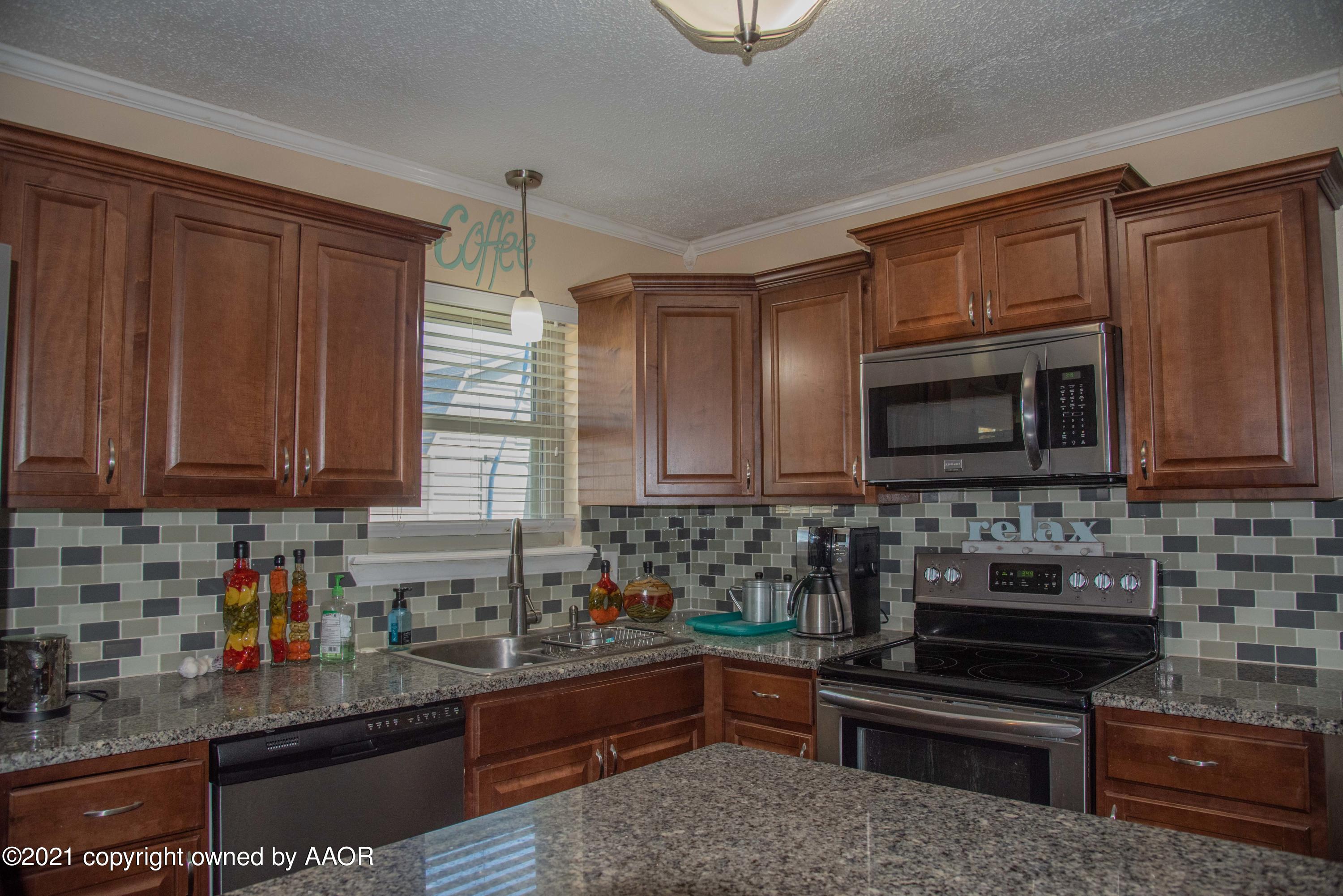 5101 South Austin Street Amarillo, TX 79110 - Photo 8 of 24 a kitchen with stainless steel appliances granite countertop a stove a sink dishwasher and a microwave oven with cabinets
