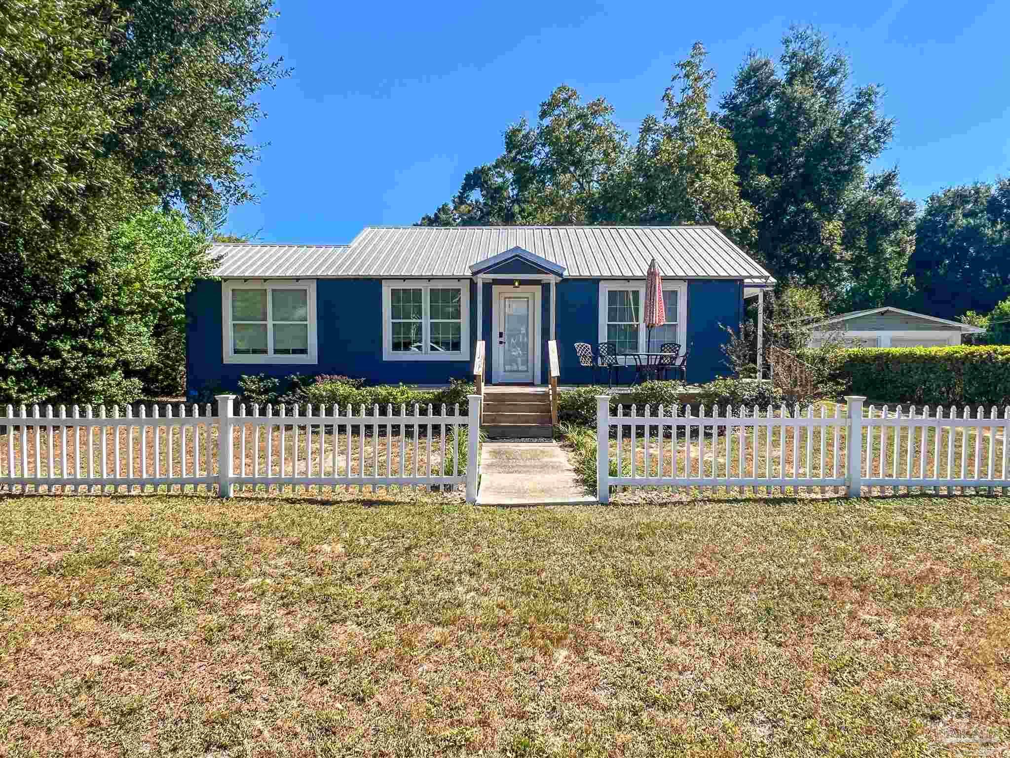 1315 Dexter Avenue Pensacola, FL 32507 - Photo 1 of 22 a front view of a house with a garden