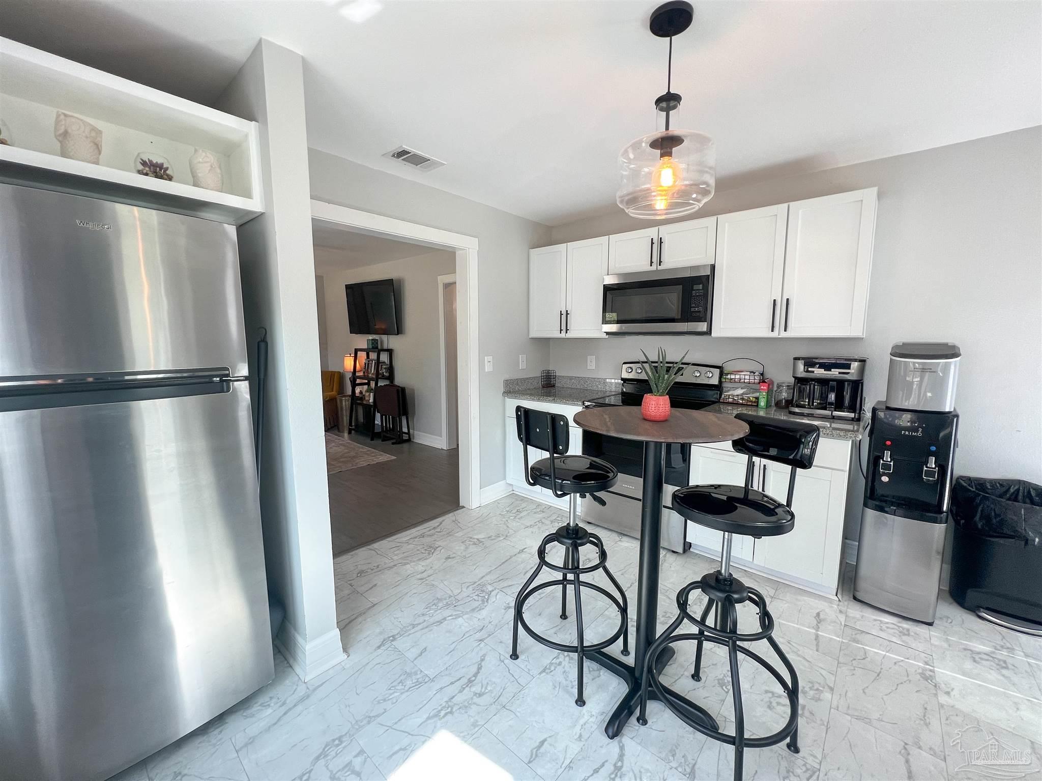 1315 Dexter Avenue Pensacola, FL 32507 - Photo 5 of 22 a kitchen with stainless steel appliances granite countertop a refrigerator and a stove top oven