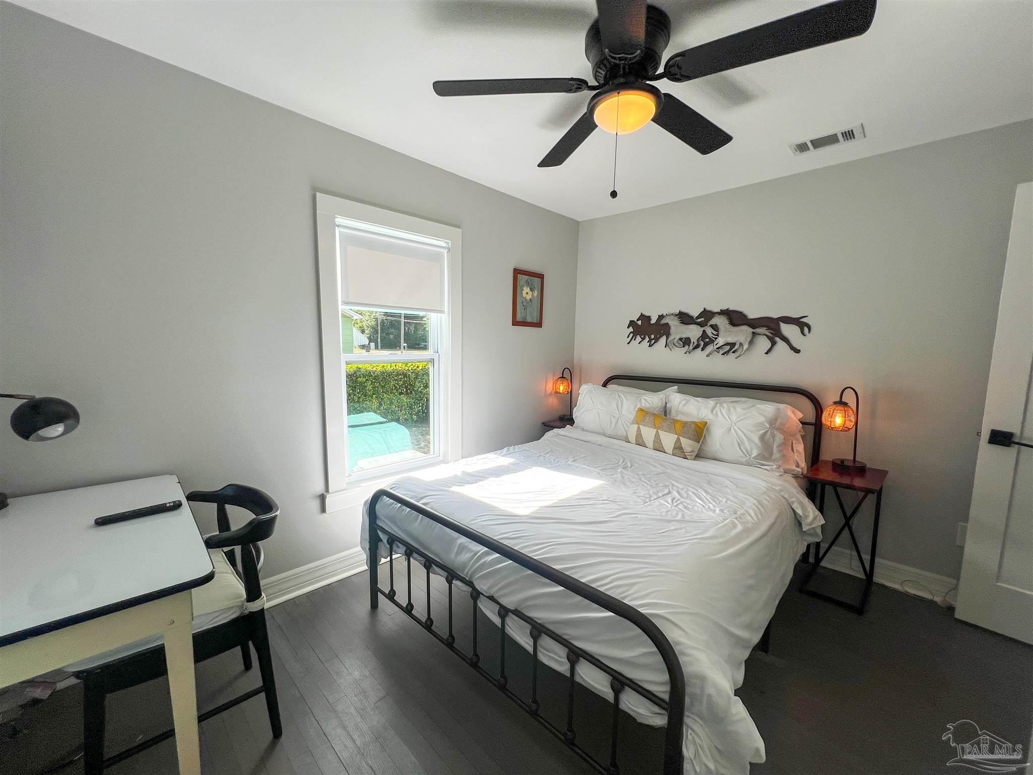1315 Dexter Avenue Pensacola, FL 32507 - Photo 8 of 22 a bedroom with a bed and a chandelier