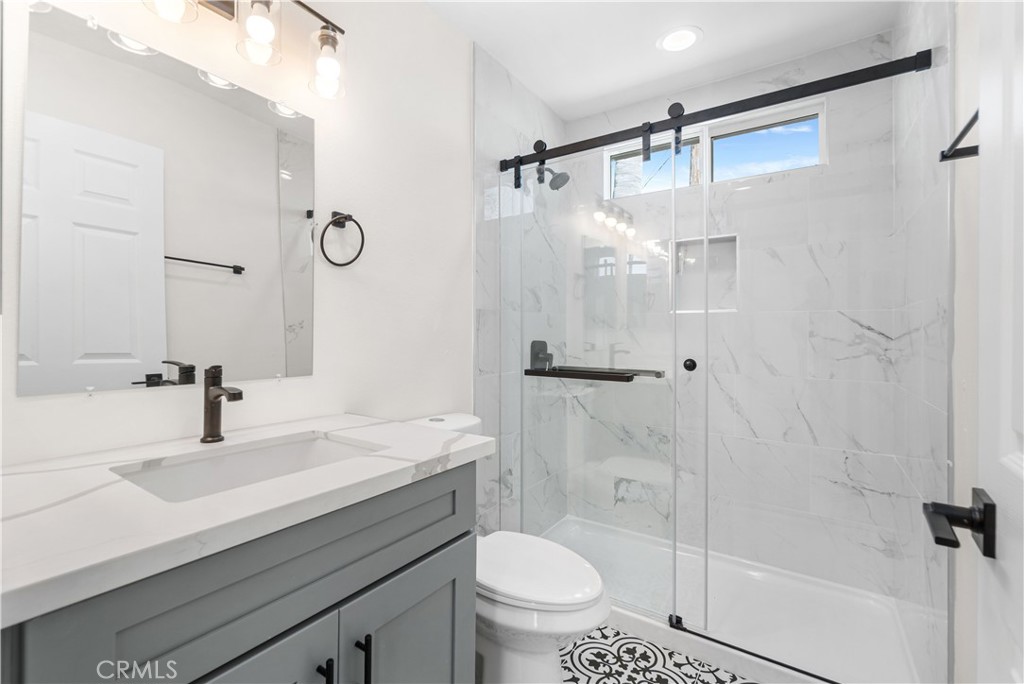 523 West 12th Street, Unit 2 San Pedro, CA 90731 - Photo 14 of 17 a bathroom with a sink toilet a mirror and shower