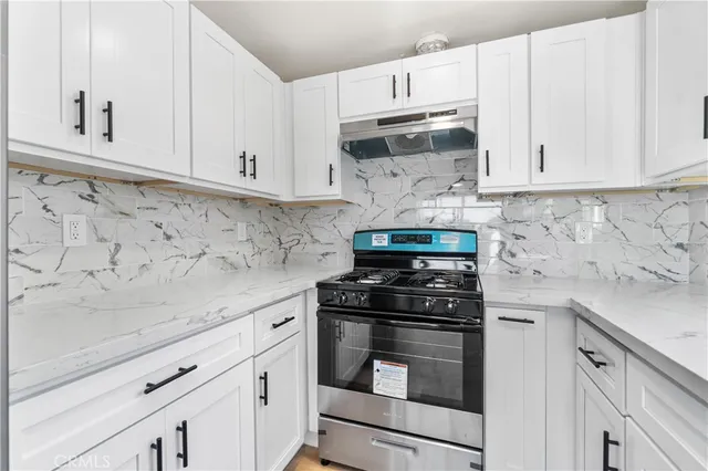 a kitchen with white cabinets and appliances
