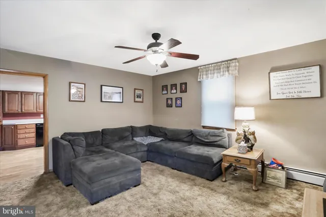 a living room with furniture and a ceiling fan