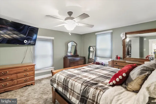 a bedroom with a bed and a mirror on the dresser