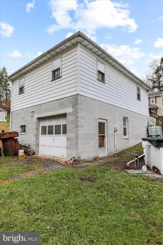 a view of a backyard with table and chairs and a large tree