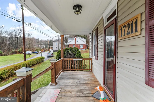 a view of a porch with wooden floor and floor to ceiling window