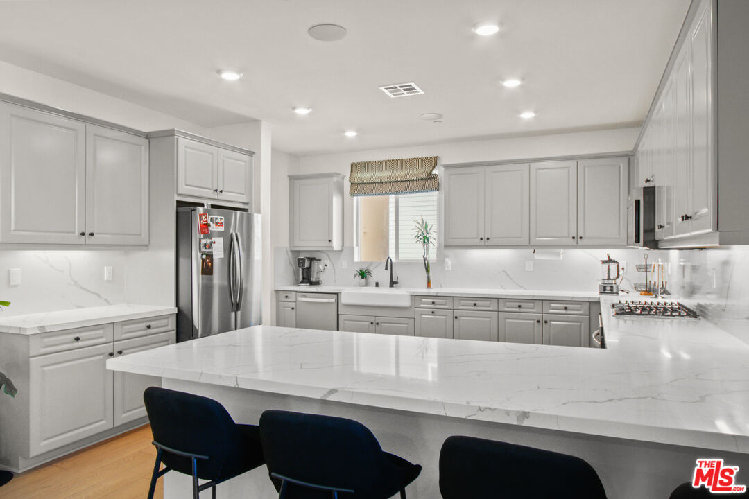 764 Daniel Freeman Circle Inglewood, CA 90301 - Photo 16 of 35 a kitchen with a dining table chairs refrigerator and cabinets