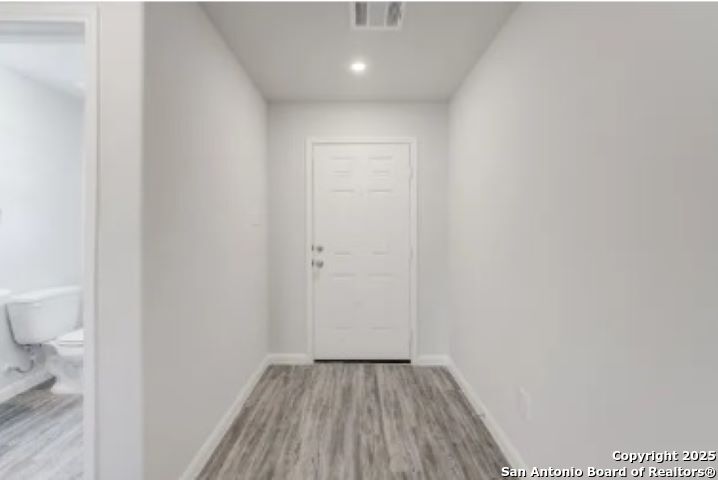 617 Cadena Loop Kenedy, TX 78119 - Photo 11 of 21 a view of a hallway with wooden floor and a toilet
