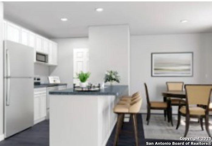 617 Cadena Loop Kenedy, TX 78119 - Photo 15 of 21 a kitchen with stainless steel appliances kitchen island granite countertop a dining table chairs and a refrigerator