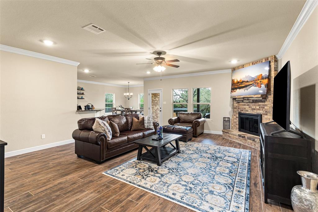 223 Cottongame Road Weatherford, TX 76088 - Photo 7 of 39 a living room with fireplace furniture flat screen tv and couches