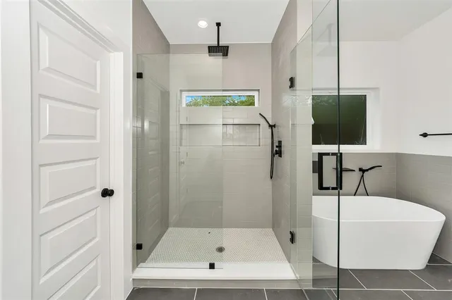 a bathroom with a tub sink and mirror