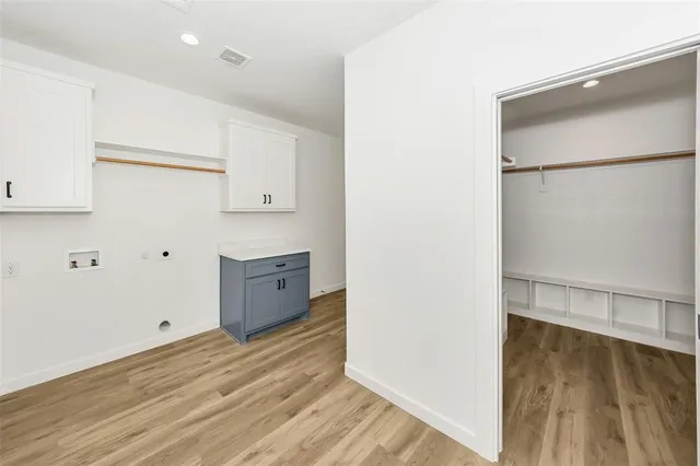 a view of storage and utility room with wooden floor
