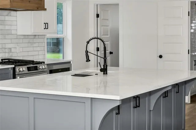 a kitchen with a sink a counter and a stove