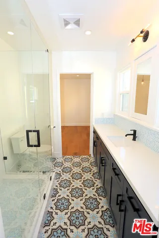 a spacious bathroom with a granite countertop sink and a bathtub