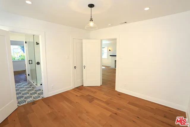 a view of a room with wooden floor cabinet and a bathroom