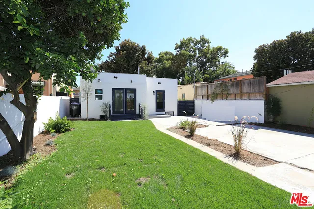 a view of a house with backyard and a tree