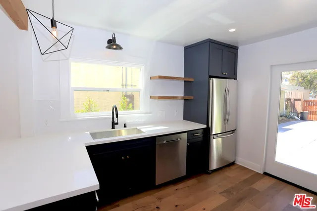 a kitchen with a sink a refrigerator and window